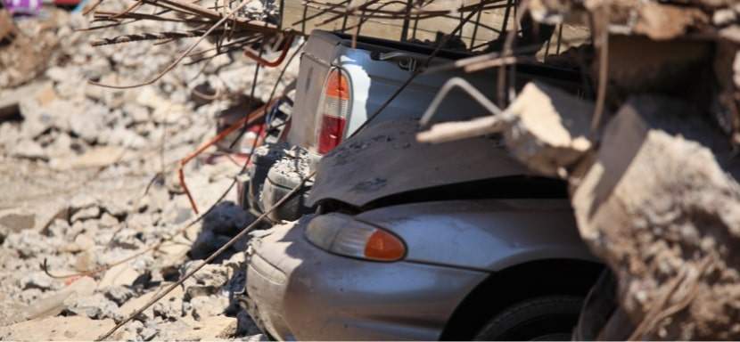 A vehicle caught under debris from a powerful earthquake.