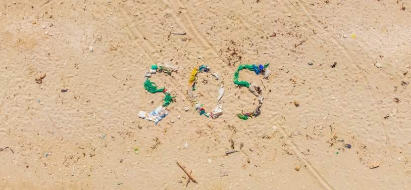 SOS made out of debris found on a beach to signal for help.