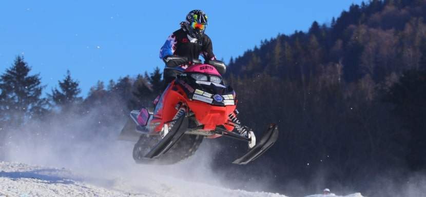 A person surviving a snowmobile accident in snowy terrain.