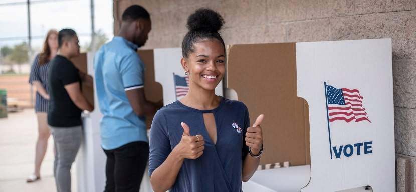 A first-time voter confidently casting her ballot.