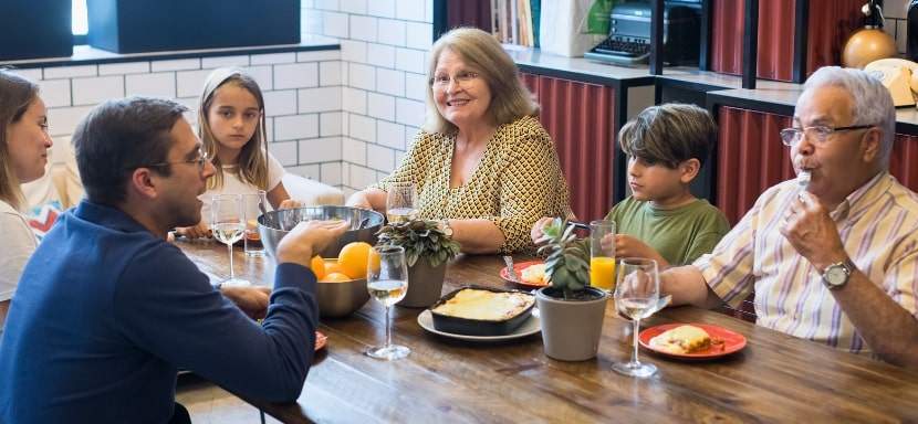 A person talking nervously at a dinner table with their in-laws.